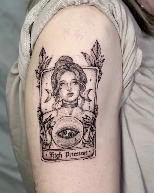 Fine line High Priestess tarot card tattoo with a portrait and an eye on the upper arm