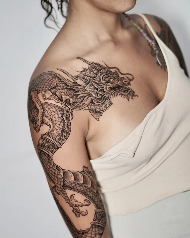 Japanese style dragon in black and grey wrapping the shoulder and arm