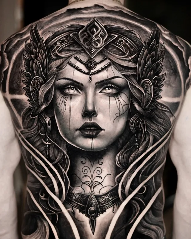 Full back piece of a goddess with a crown in black and grey realism